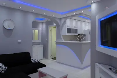a living room with a black couch and a kitchen at Apartment 