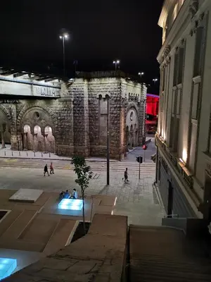 a large building with people sitting in a courtyard at night at K43 Rooms in Belgrade