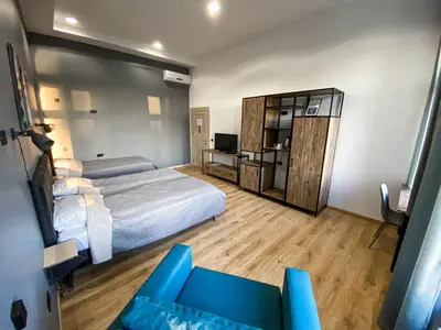 a bedroom with a bed and a couch and a television at K43 Rooms in Belgrade