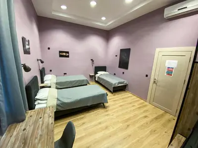 two beds in a room with purple walls at K43 Rooms in Belgrade