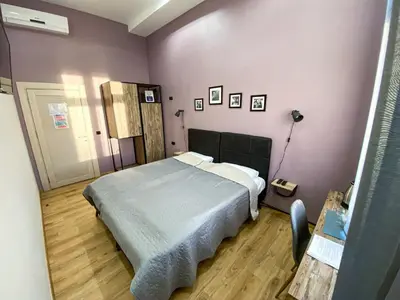 a bedroom with a bed and a purple wall at K43 Rooms in Belgrade