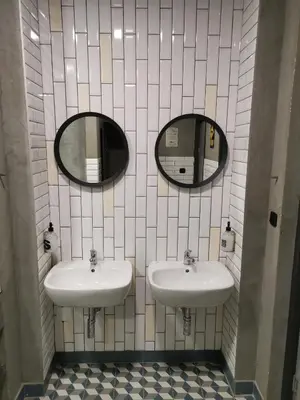 two sinks in a bathroom with two mirrors at K43 Rooms in Belgrade