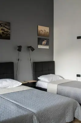 two beds sitting in a room with two lamps at K43 Rooms in Belgrade