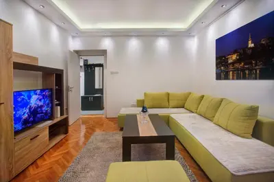a living room with a couch and a tv at Balkanic Star Belgrade in Belgrade