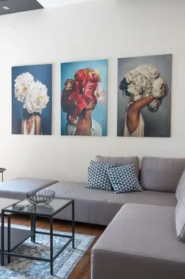 a living room with four paintings on the wall at Lux apartment in city center in Belgrade