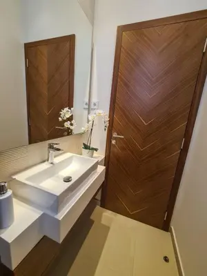 a bathroom with a white sink and a wooden door at Lux apartment in city center in Belgrade