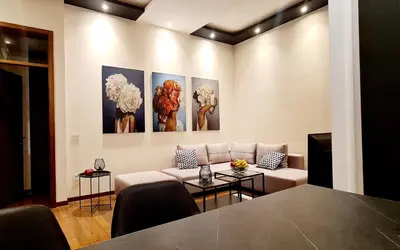a living room with a couch and paintings on the wall at Lux apartment in city center in Belgrade