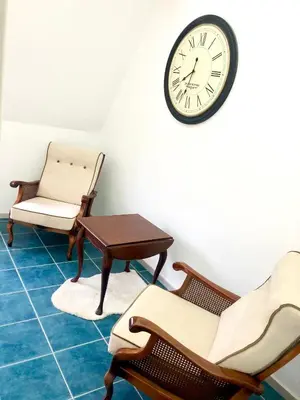 a room with chairs and a clock on the wall at Apartment Duplex in Pančevo