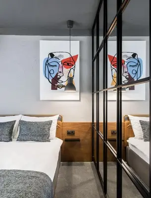 a bedroom with two beds and paintings on the wall at 7 Rooms Suites in Belgrade