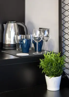 a shelf with wine glasses and a potted plant at 7 Rooms Suites in Belgrade