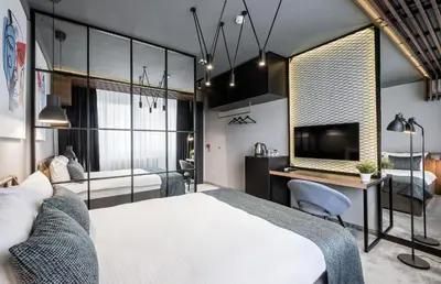 a bedroom with a bed and a desk and a tv at 7 Rooms Suites in Belgrade