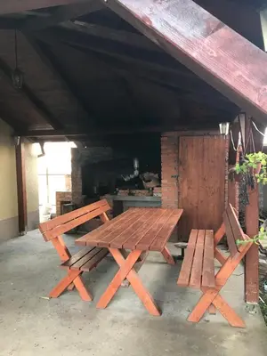 a picnic table and two benches under a roof at MM Apartmani in Belgrade