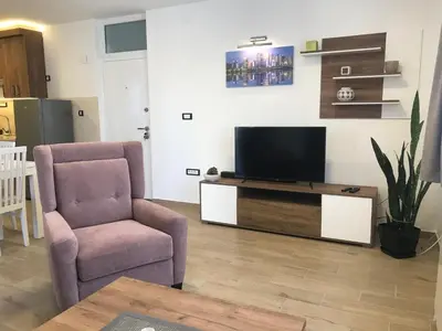 a living room with a tv and a chair at MM Apartmani in Belgrade
