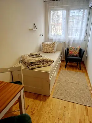 a bedroom with a bed and a window and a chair at Sava river in Belgrade