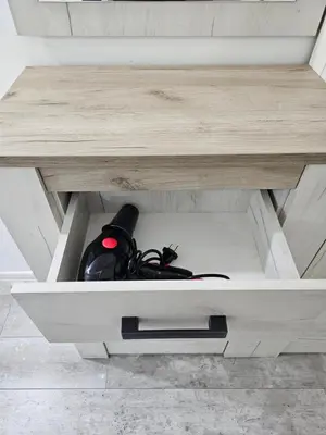 a wooden desk with a black controller in a drawer at Apartman Viktor in Belgrade