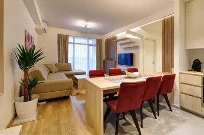 a kitchen and living room with a table and chairs at MVP apartment - Belgrade Waterfront in Belgrade