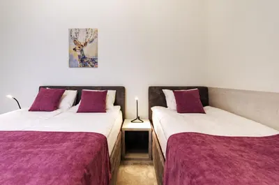 two beds in a room with purple and white sheets at MVP apartment - Belgrade Waterfront in Belgrade