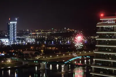 a city lit up at night with a building at MVP apartment - Belgrade Waterfront in Belgrade