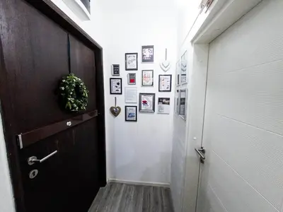 a hallway with a door and pictures on the wall at Apartment Tesla Wizard in Belgrade