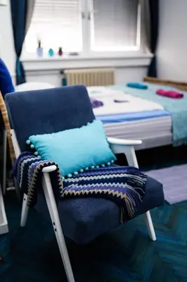 a bedroom with a blue chair and a bed at Apartment Tesla Wizard in Belgrade