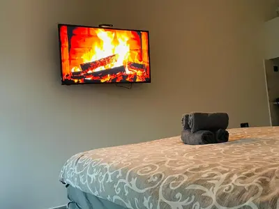 a flat screen tv hanging on a wall above a bed at Luxury Centar in Arandjelovac