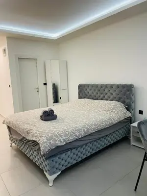a bedroom with a bed with a hat on it at Luxury Centar in Arandjelovac