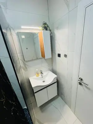 a white bathroom with a sink and a mirror at Luxury Centar in Arandjelovac