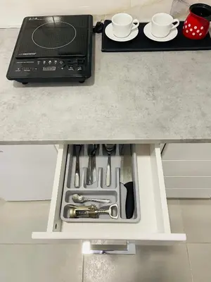 a kitchen counter with an open drawer with utensils at Luxury Centar in Arandjelovac