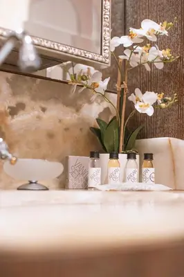 a bathroom sink with three bottles on a counter at Eclat Luxury Hotel in Belgrade