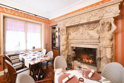 a restaurant with a fireplace and tables and chairs at Eclat Luxury Hotel in Belgrade