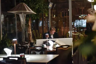 a man sitting at a table in a restaurant at Eclat Luxury Hotel in Belgrade