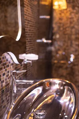 a sink in a bathroom with a brick wall at Eclat Luxury Hotel in Belgrade