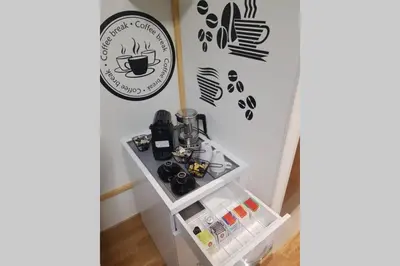 a table with a coffee maker and a sign on a wall at Beograd Promenada Waterfront in Belgrade