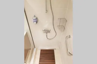 a bathroom with a shower with a wooden floor at Beograd Promenada Waterfront in Belgrade