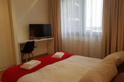 a bedroom with a bed and a television and a chair at Belgrade Waterfront Lux 1 in Belgrade