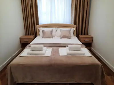 a bedroom with a large bed with two towels on it at Divizija Lux apartments in Belgrade
