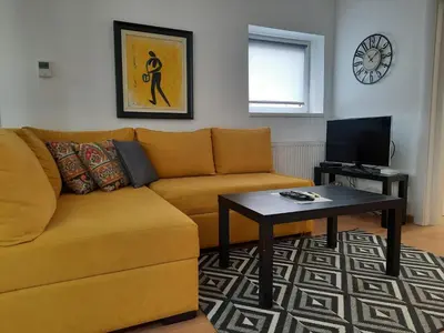 a living room with a yellow couch and a table at Divizija Lux apartments in Belgrade
