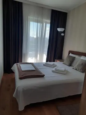 a bedroom with a large white bed with a window at Divizija Lux apartments in Belgrade