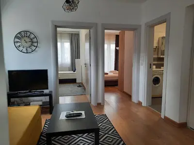 a living room with a couch and a clock on the wall at Divizija Lux apartments in Belgrade