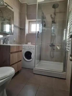 a bathroom with a shower and a washing machine at Divizija Lux apartments in Belgrade