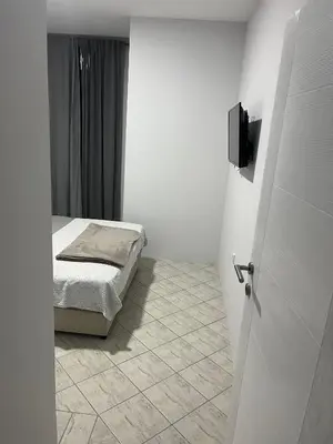 a bedroom with a bed and a tv on the wall at MAGIC M Apartment in Mali Mokri Lug