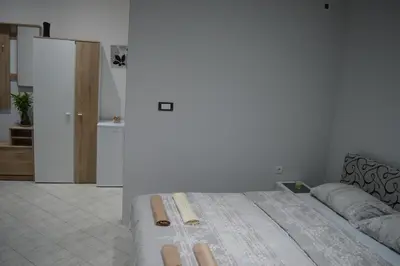 a bedroom with a bed and a room with a kitchen at MAGIC M Apartment in Mali Mokri Lug