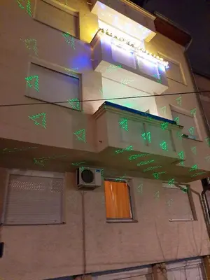 a building with green lights on the side of it at Apartments best city place in Belgrade