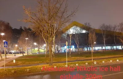 a tree in front of a building at night at Apartments best city place in Belgrade