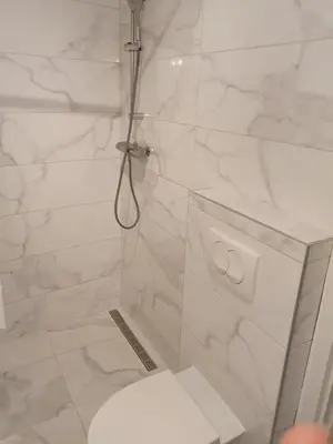 a white bathroom with a shower and a toilet at Mosaic in Belgrade