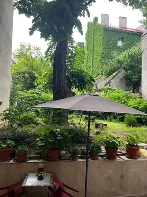 an umbrella in front of a garden with plants at Mosaic in Belgrade