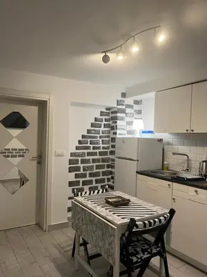 a kitchen with a table and a brick wall at Mosaic in Belgrade