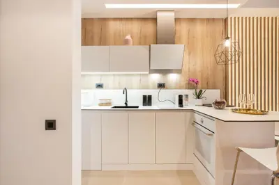 a kitchen with white cabinets and wooden walls at Leo Executive Suite, Self Check-In, Free Garage, FAST Wi-Fi, Concierge in Belgrade