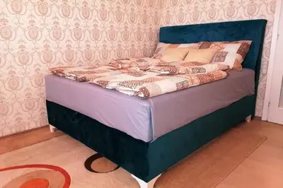 a bed with a blue headboard in a bedroom at Oasis felix apartment in Belgrade