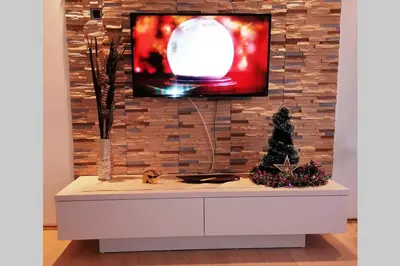 a tv on a brick wall with a tv on top at Oasis felix apartment in Belgrade